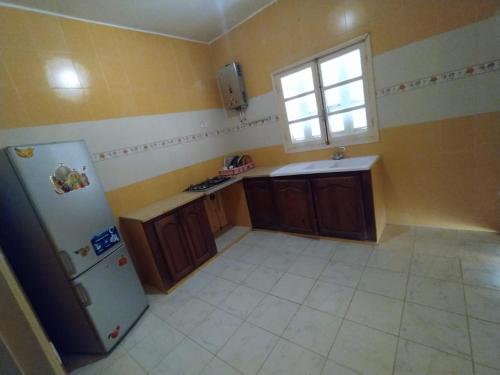 a kitchen with a refrigerator and a window at Apartments in Djerba