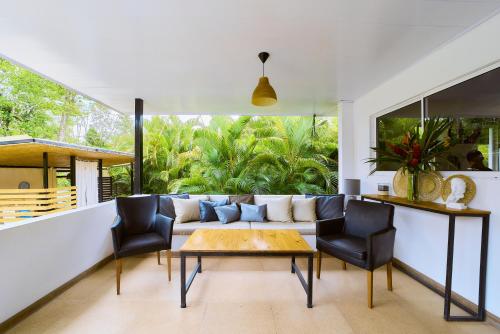 a living room with a couch and chairs at La Tica y La Gata in Puerto Viejo