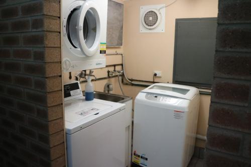 a kitchen with a sink and a washing machine at Corowa Golf Club Motel in Corowa