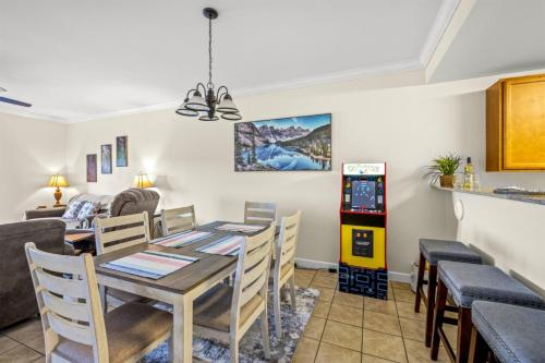 a dining room and living room with a table and chairs at Smoky Mountain View Condo- Hot Tub, Indoor Pool, Walking Path, Playground in Pigeon Forge
