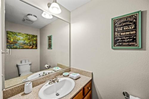 a bathroom with a sink and a mirror at Smoky Mountain View Condo- Hot Tub, Indoor Pool, Walking Path, Playground in Pigeon Forge
