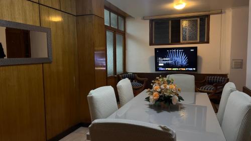 Un comedor con mesa y sillas y un televisor. en Tranquilo Departamento en Pleno Centro de la Ciudad, en Antofagasta