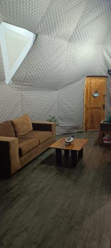 a living room with a couch and a coffee table at Espectacular Domo Rústico con Vista en Los Vilos, equipado hasta 5 personas in Los Vilos