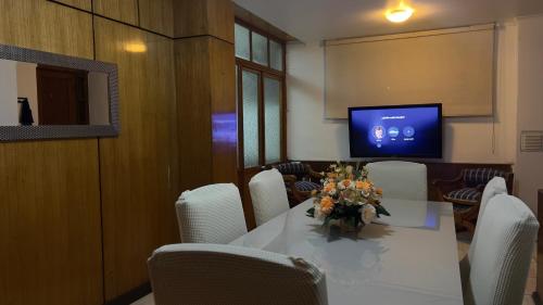 Sala de conferencias con mesa, sillas y TV en Tranquilo Departamento en Pleno Centro de la Ciudad, en Antofagasta