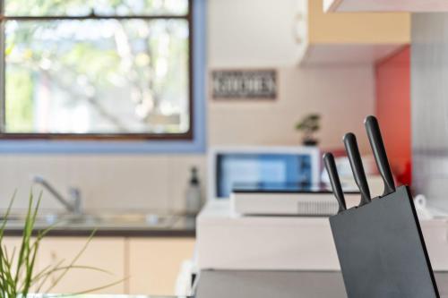 a kitchen with a table with a laptop on it at Luxe Double Room - Nearby Stations & Eateries - Shared Bathroom in Blacktown