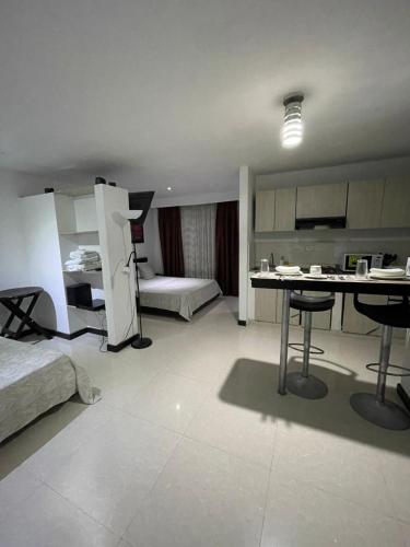a living room with a bed and a table in a room at Hotel Plaza Norte Cali in Cali