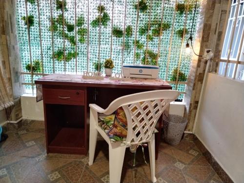 a desk with a chair in front of a window at Casa Lilia Airport in Panama City