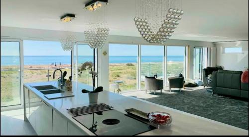 a white kitchen with a view of the ocean at Seaside Place on Shoreham Beach with Hot Tub in Shoreham-by-Sea