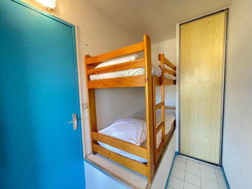 Cette chambre comprend 2 lits superposés et une porte bleue. dans l'établissement Studio Cabine à Sète: Véranda, Parking, Ascenseur, Plage à 300m - FR-1-338-44, à Sète