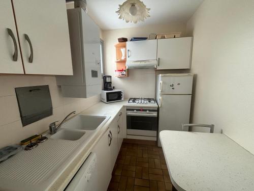 une petite cuisine avec un évier et un réfrigérateur dans l'établissement Appartement T3 au 6e étage avec balcon et vue mer - FR-1-197-200, à Les Sables-dʼOlonne