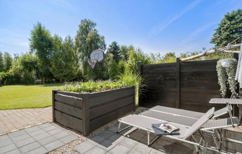 une terrasse avec une table et des chaises ainsi qu'un panier de basket-ball. dans l'établissement 3 Bedroom Stunning Home In Højby, à Højby