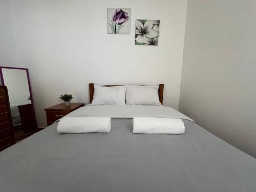 a white bed with two white pillows on it at Hermosa casa a 15 min de Paracas in Pisco