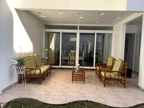 a living room with chairs and a table at Hermosa casa a 15 min de Paracas in Pisco