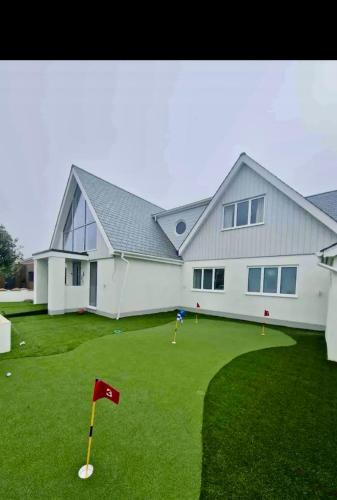 a white house with a red flag in the yard at Seaside Place on Shoreham Beach with Hot Tub in Shoreham-by-Sea