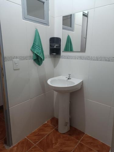 a bathroom with a sink and a mirror at Hostel el Amanecer in Puerto Iguazú