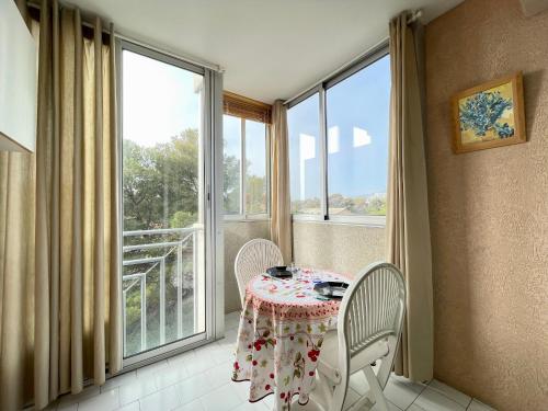une table et des chaises dans une pièce avec une fenêtre dans l'établissement Studio à Sète proche plage, animaux admis, parking - FR-1-338-95, à Sète