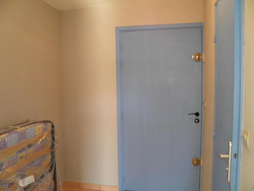 - une porte bleue dans une chambre avec un lit dans l'établissement Studio près de la plage avec parking à Sète - FR-1-338-104, à Sète