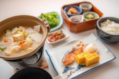 a table with a bowl of soup and a plate of food at Yumotoya in Matsumoto