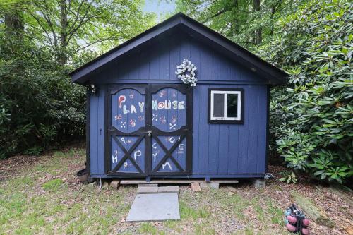 a blue shed with a door with graffiti on it at Green Acres Nature Escape in Long Pond