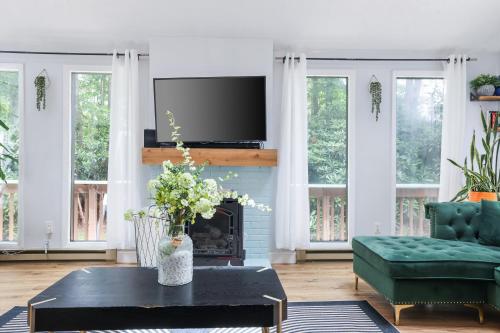 a living room with a fireplace and a tv at Green Acres Nature Escape in Long Pond