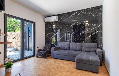 a living room with a couch and a marble wall at Nice Home In Trbounje With Wifi in Trbounje