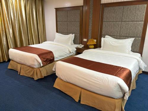 a hotel room with two beds in a room at Lido De Paris Hotel in Manila