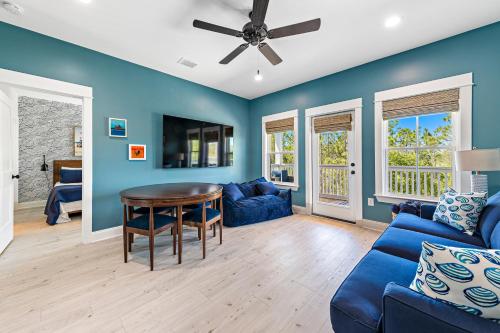 a living room with blue walls and a ceiling fan at Whiskey Sands - Luxury by Gulf State Park, Great Views, Walk to Beach and Restaurants, Beautiful Pool, Fenced Yard! in Orange Beach