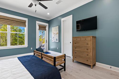 a bedroom with blue walls and a bed and a dresser at Whiskey Sands - Luxury by Gulf State Park, Great Views, Walk to Beach and Restaurants, Beautiful Pool, Fenced Yard! in Orange Beach