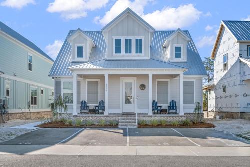 a white house with a blue roof at Whiskey Sands - Luxury by Gulf State Park, Great Views, Walk to Beach and Restaurants, Beautiful Pool, Fenced Yard! in Orange Beach