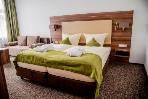 a hotel room with a large bed with towels on it at Hotel Villa Elsa in Bad Kissingen