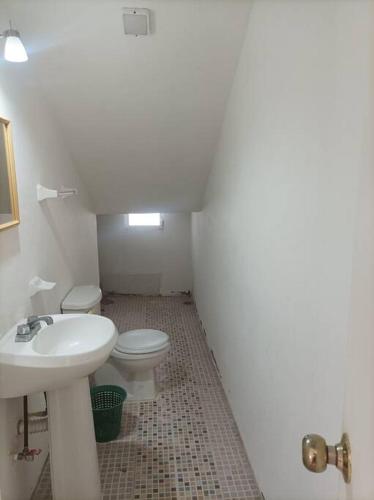 a white bathroom with a sink and a toilet at Casa Fefe Huatulco in Tangolunda