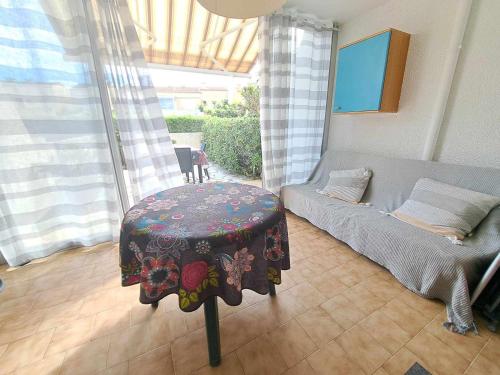 un salon avec un canapé et une table dans l'établissement Appartement T2 avec Piscine, Terrasse et Parking Privé à Marseillan - FR-1-326-827, à Marseillan