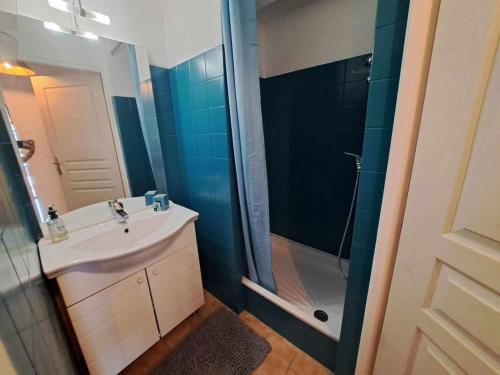 une salle de bain avec un lavabo et une douche dans l'établissement Appartement T2 avec Piscine, Terrasse et Parking Privé à Marseillan - FR-1-326-827, à Marseillan