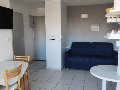 un salon avec un canapé bleu et une table dans l'établissement Appartement Climatisé - Parking - Piscine - Près de la Plage - FR-1-801-6, au Cap d'Agde