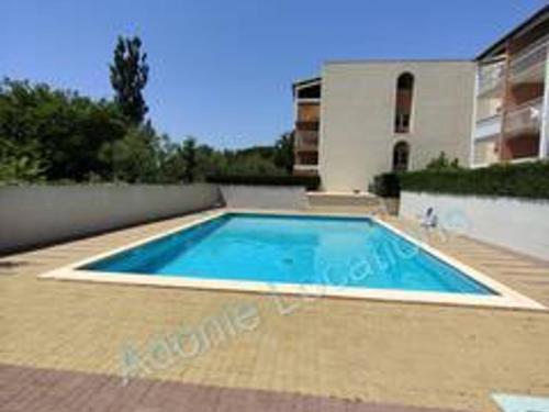 une piscine devant une maison dans l'établissement Appartement Climatisé - Parking - Piscine - Près de la Plage - FR-1-801-6, au Cap d'Agde
