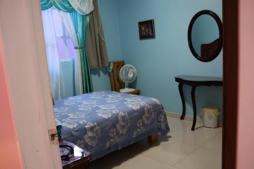 a blue bedroom with a bed and a mirror at Casa céntrica en Morelia. in Morelia