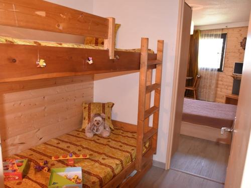 - une chambre avec des lits superposés et un lit avec un ours en peluche dans l'établissement Appartement cosy proche des pistes avec parking à Montgenèvre - FR-1-266-229, à Montgenèvre
