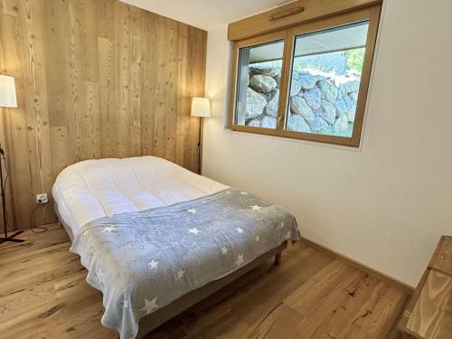 une chambre avec un lit et une fenêtre dans l'établissement Appartement Neuf 3 Pièces avec Terrasse et Jardin, Proche Remontées Mécaniques, Parking Inclus - FR-1-597-179, à Combloux