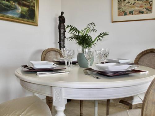 - une table blanche avec des assiettes et des verres dans l'établissement Appartement pieds dans l'eau: 2 pièces, grande terrasse, climatisation, Villeneuve-Loubet - FR-1-252A-127, à Villeneuve-Loubet