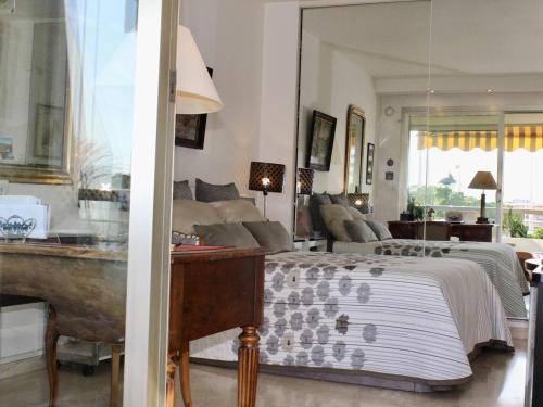 une chambre avec un lit et un salon dans l'établissement Appartement pieds dans l'eau: 2 pièces, grande terrasse, climatisation, Villeneuve-Loubet - FR-1-252A-127, à Villeneuve-Loubet