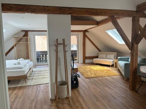 a room with a bed and a couch in a room at ღLIBORIA I Loft am Riegsee in Aidling