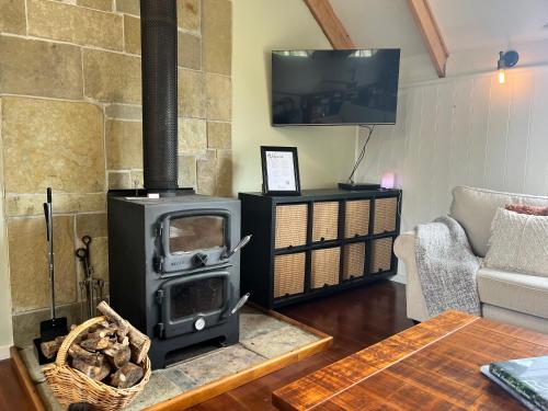 a living room with a wood stove in a room at The Loft at Shelford in Doroq