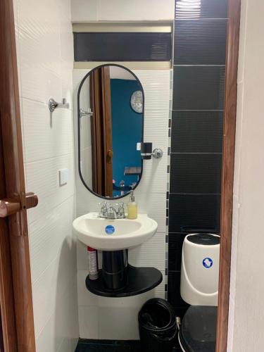 une salle de bain avec un lavabo et un miroir dans l'établissement Estudio en 3 piso - Con todo lo necesario al norte de la Cali., à Cali