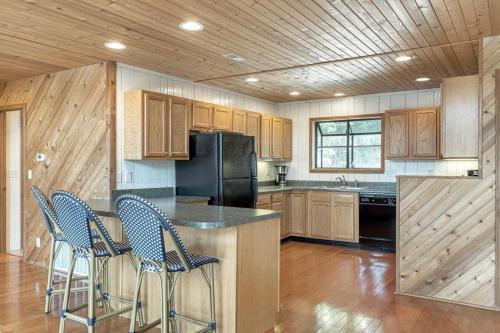 a kitchen with wooden cabinets and a black refrigerator at Linden Lakefront Retreat with Kayaks in Innsbrook