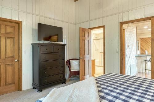 a bedroom with a bed and a dresser with a television at Linden Lakefront Retreat with Kayaks in Innsbrook