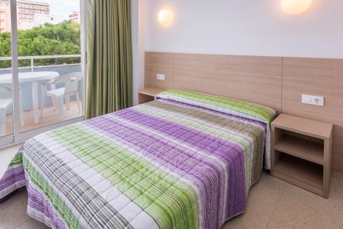 a hotel room with a bed and a balcony at Apartaments Solmar in Blanes