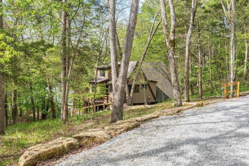 a house in the woods next to a road at Acorn Lake Lodge On Lake Aspen in Innsbrook