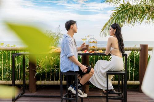 a man and a woman sitting at a table with a drink at DoubleTree by Hilton Shanwei in Shanwei