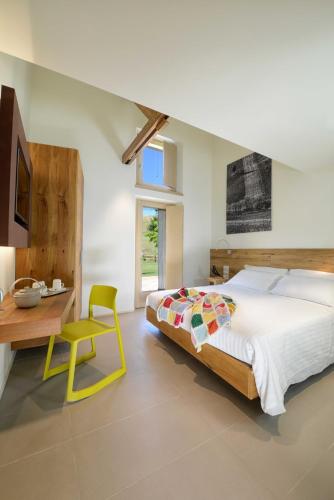 a bedroom with a bed and a desk and a chair at Il Gallo Senone Resort e Spa in Senigallia
