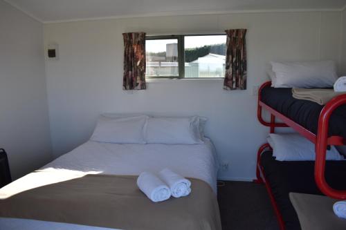 a small bedroom with two beds and a window at Route79 Holiday Park Geraldine in Geraldine